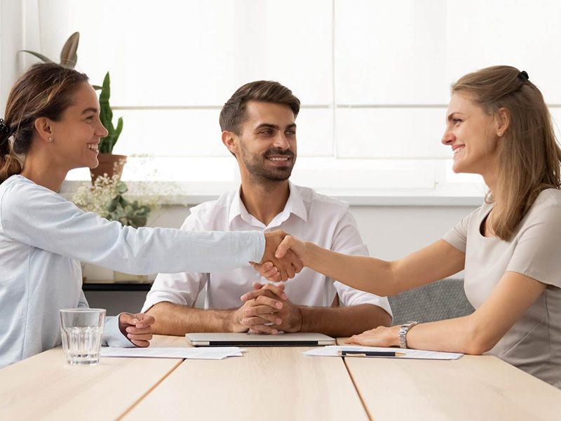 Two people reaching an agreement with a mediator present